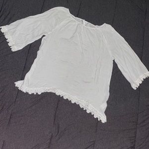 White blouse with the ends of the sleeves outlined with white flower lace